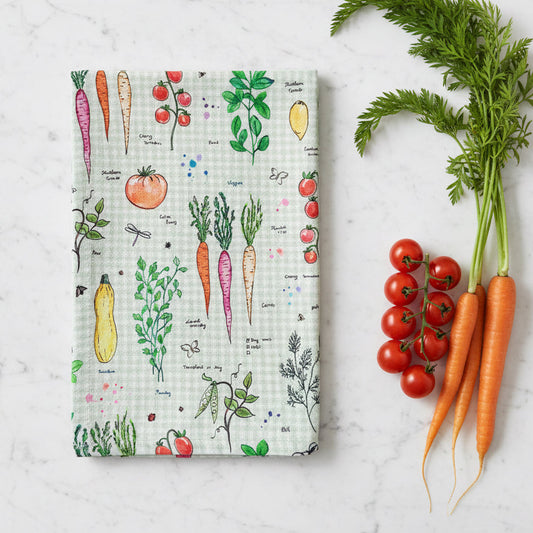 Folded vegetable pattern cotton-linen tea towel on wooden surface