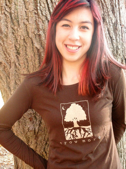 Woman wearing dark brown 'Grow More' tree long sleeve shirt made from bamboo and organic cotton, great for gardening and nature-inspired fashion.