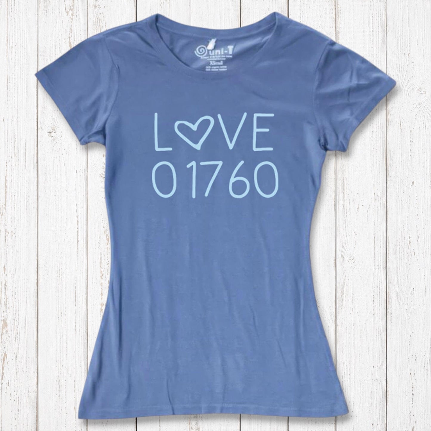 Blue women's T-shirt made of organic cotton and bamboo with 'LOVE' and '01760' printed in light blue, casual wear on white wooden background