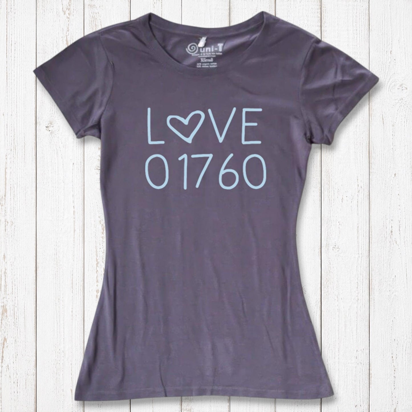 Dark gray women's T-shirt with light blue 'LOVE' graphic featuring a heart-shaped 'O' and the number 01760, laid flat on a white wooden background
