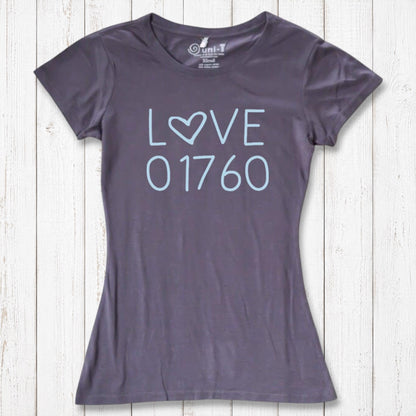 Dark gray women's T-shirt with light blue 'LOVE' graphic featuring a heart-shaped 'O' and the number 01760, laid flat on a white wooden background