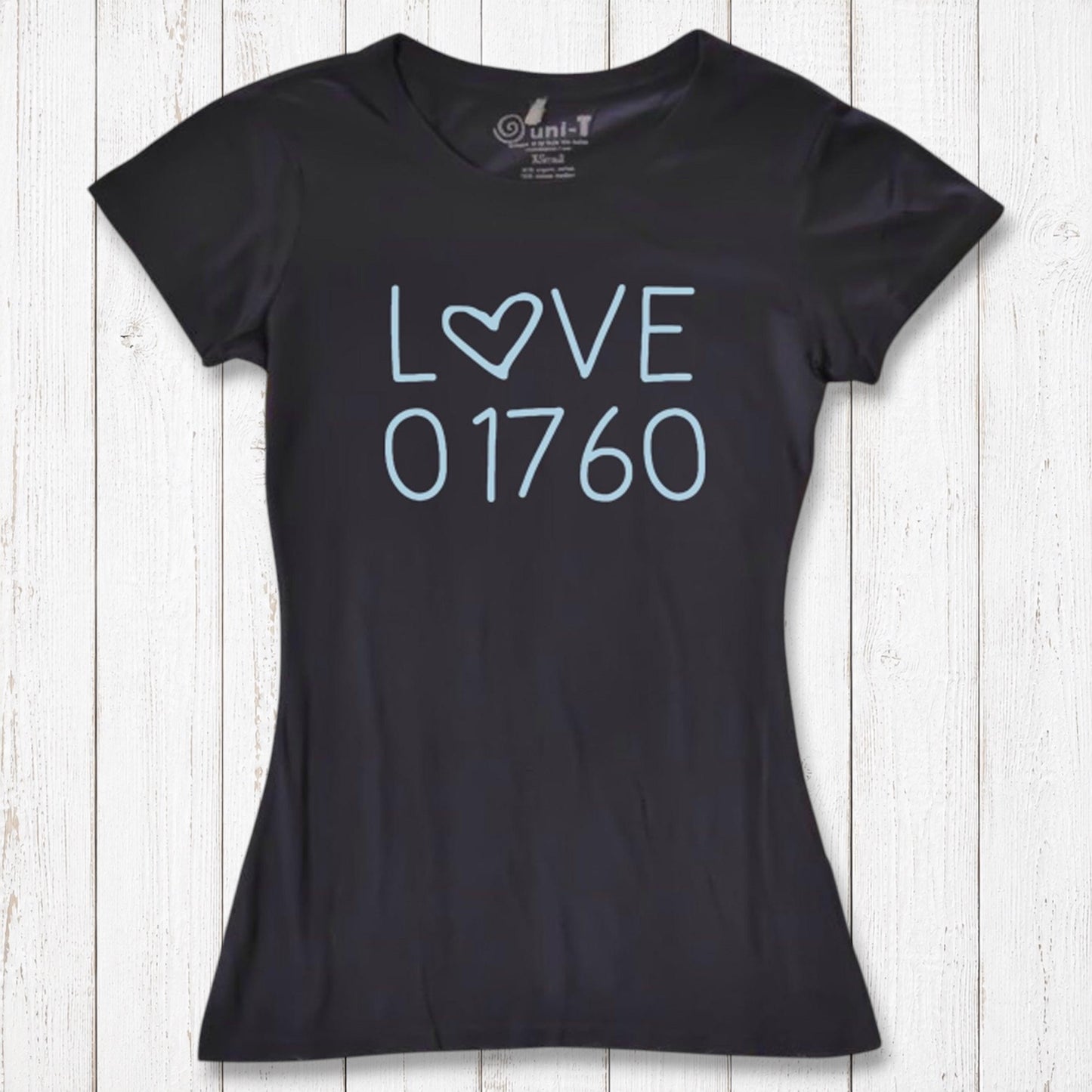 Black women's T-shirt made of organic cotton and bamboo with a light blue 'LOVE' graphic and the number 01760, laid on white wooden background