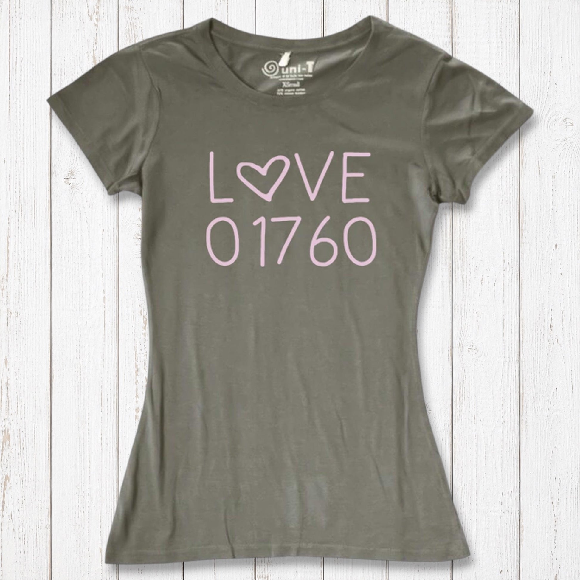 Olive green women's T-shirt with pink 'LOVE' text and heart symbol, made of organic cotton and bamboo, casual fit, on white wooden background
