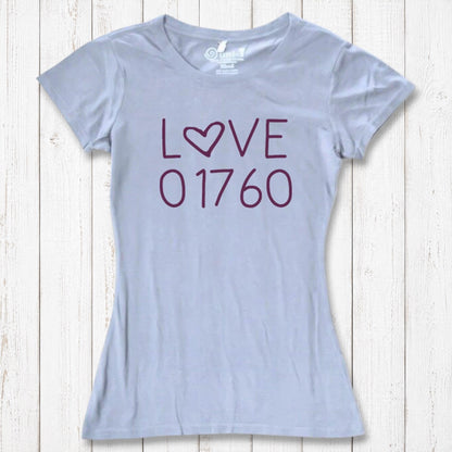 Light gray women's T-shirt made of organic cotton and bamboo with 'LOVE' printed in purple, featuring a heart-shaped 'O', laid flat on white wooden background
