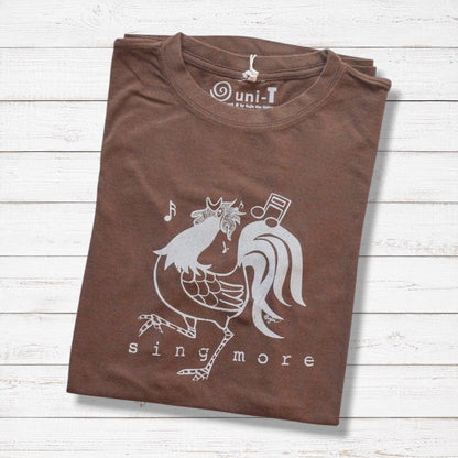 Folded brown 'Sing More' rooster t-shirt for men made from bamboo and organic cotton, featuring a funny farm animal graphic.