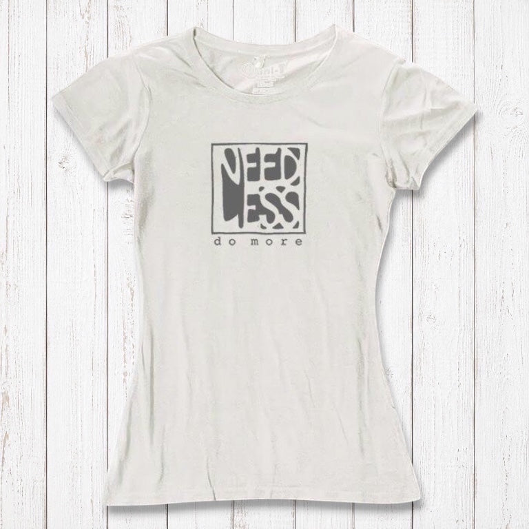 Ivory white women's bamboo and organic cotton t-shirt with 'Need Less Do More' quote. Minimalist and eco-conscious fashion top.
