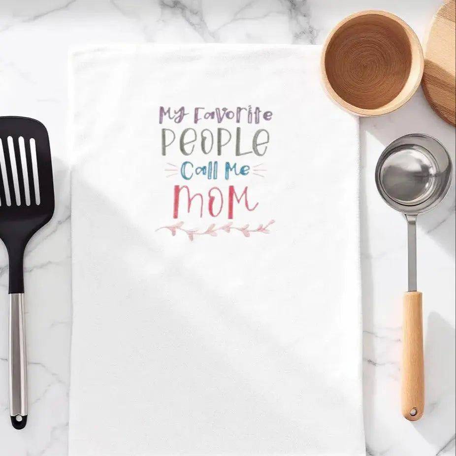 Embroidered kitchen towel with 'My favorite people call me Mom' text, styled for heartfelt home decor. Ideal small gift for moms in the kitchen.