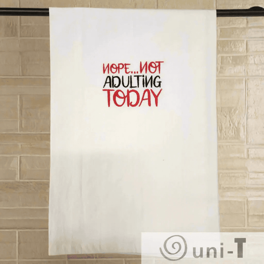 Nope... not adulting Towel - Funny Embroidered Towel hanging on a rod against a tiled wall, perfect humorous touch for any kitchen decor.