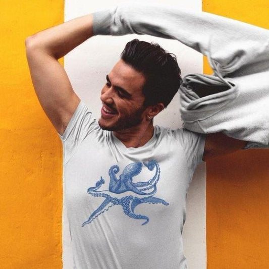 Man wearing Men's Octopus T-Shirt in bamboo and organic cotton, smiling in white tee with blue octopus print, eco-friendly sea life gift idea.