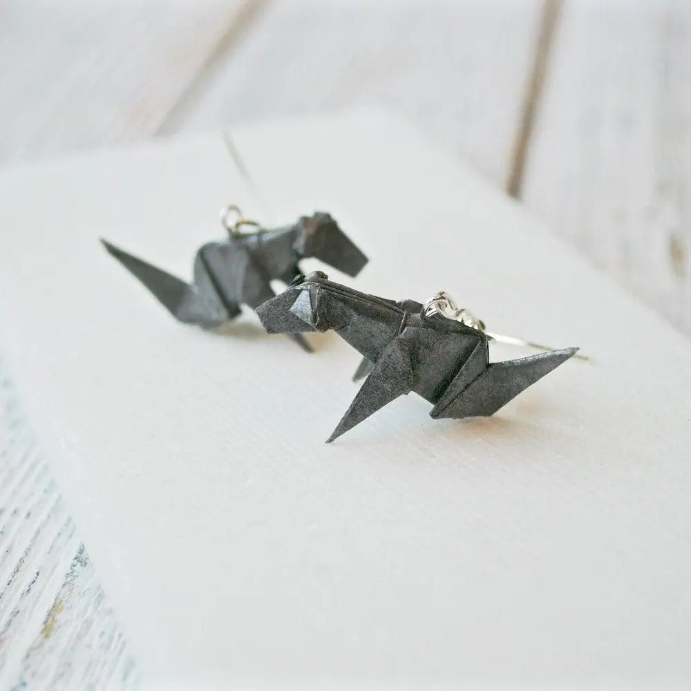 Close-up of grey origami dog earrings with detailed folds and acrylic seal, perfect as a unique jewelry gift for dog lovers.