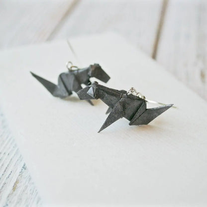 Close-up of grey origami dog earrings with detailed folds and acrylic seal, perfect as a unique jewelry gift for dog lovers.