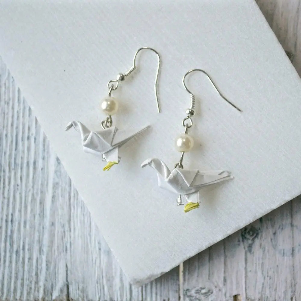 White Origami Paper Dove Earrings with pearl bead accent. Elegant and lightweight, a unique accessory for casual or formal wear.