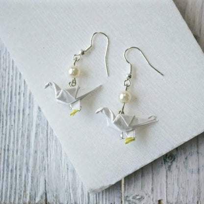White Origami Paper Dove Earrings with pearl bead accent. Elegant and lightweight, a unique accessory for casual or formal wear.