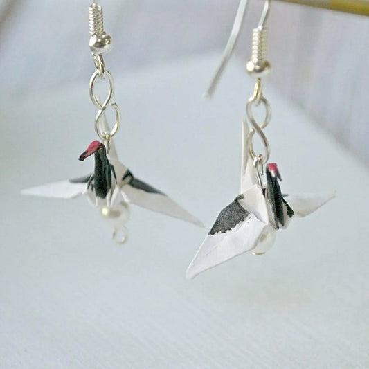 Origami red crested crane earrings featuring delicate paper cranes with black wings and red accents, sealed in acrylic for durability.
