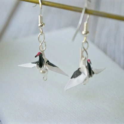 Handmade origami red crested crane earrings with black and red detailing, showcasing intricate paper folding and elegant drop design.