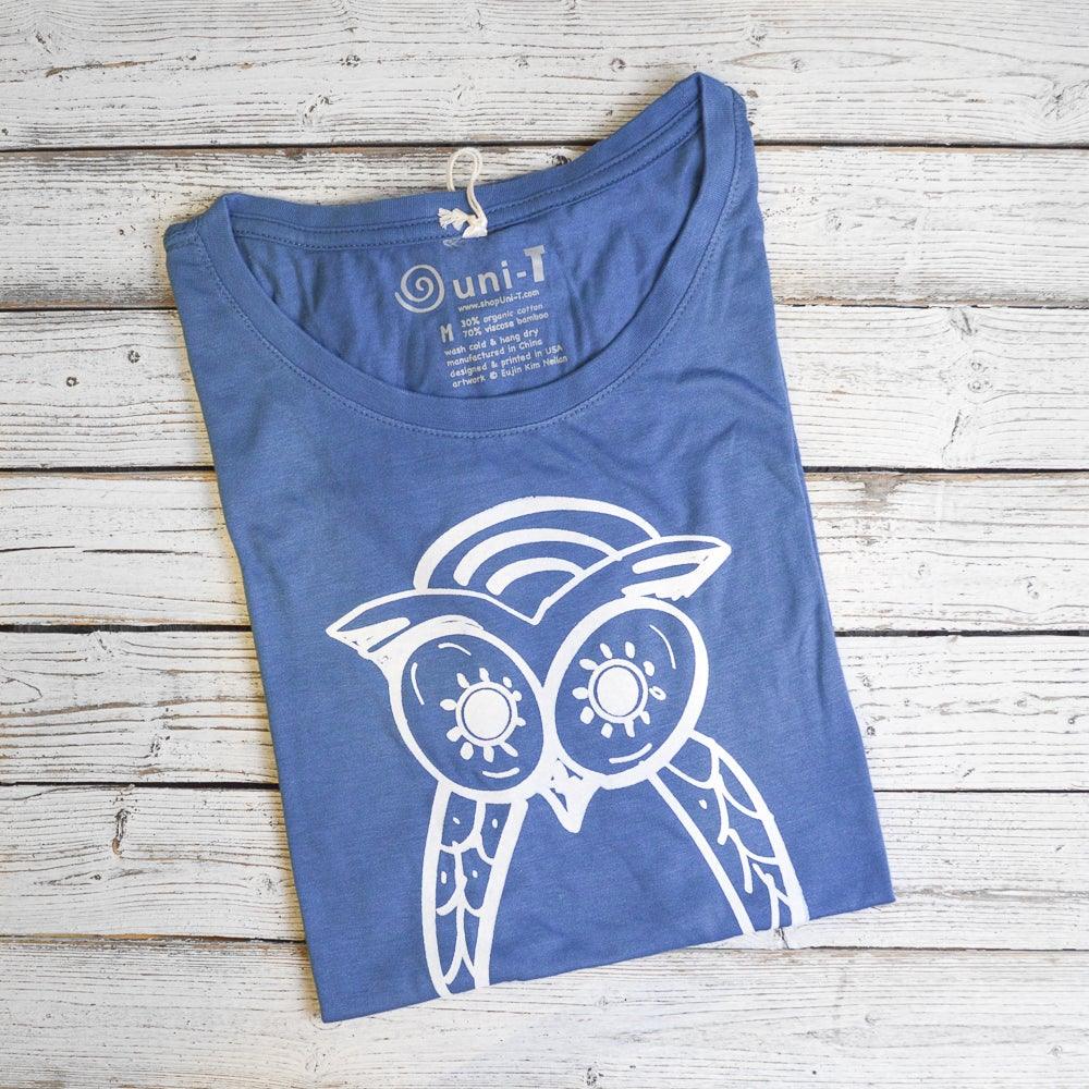 Folded blue Women’s Owl T-Shirt with white owl graphic, made from bamboo and organic cotton, eco-conscious gift for wildlife fans.