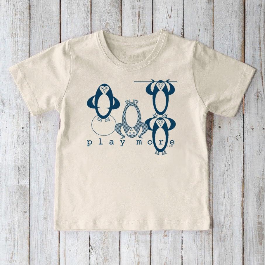 Cream-colored Kids' Penguin Organic Cotton T-Shirt with blue penguin illustrations and 'play more' text, eco-conscious sea life top for children.