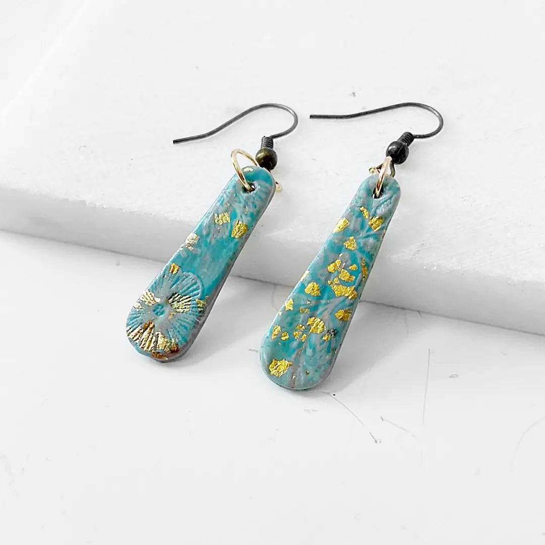 Blue and gold shimmer polymer clay earrings with black earwires. Stylish and budget-friendly accessory.