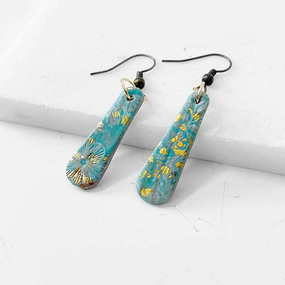 Blue and gold shimmer polymer clay earrings with black earwires. Stylish and budget-friendly accessory.