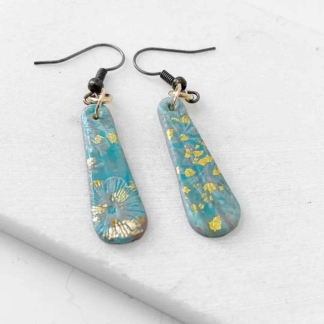 Affordable turquoise polymer clay earrings with gold accents and floral detail. Ideal for gifting or daily wear.