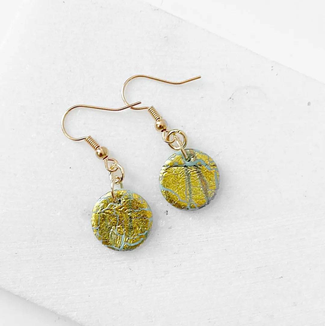 Round gold shimmer polymer clay earrings with textured surface and gold plated hooks. Elegant and affordable gift.