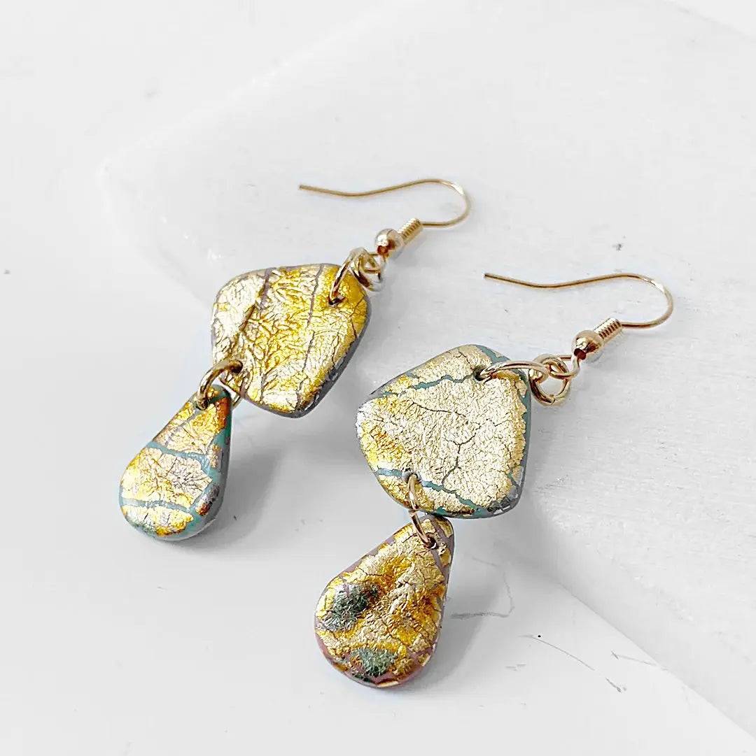 Affordable polymer clay earrings with gold shimmer and layered teardrop design. Elegant accessory for any occasion.
