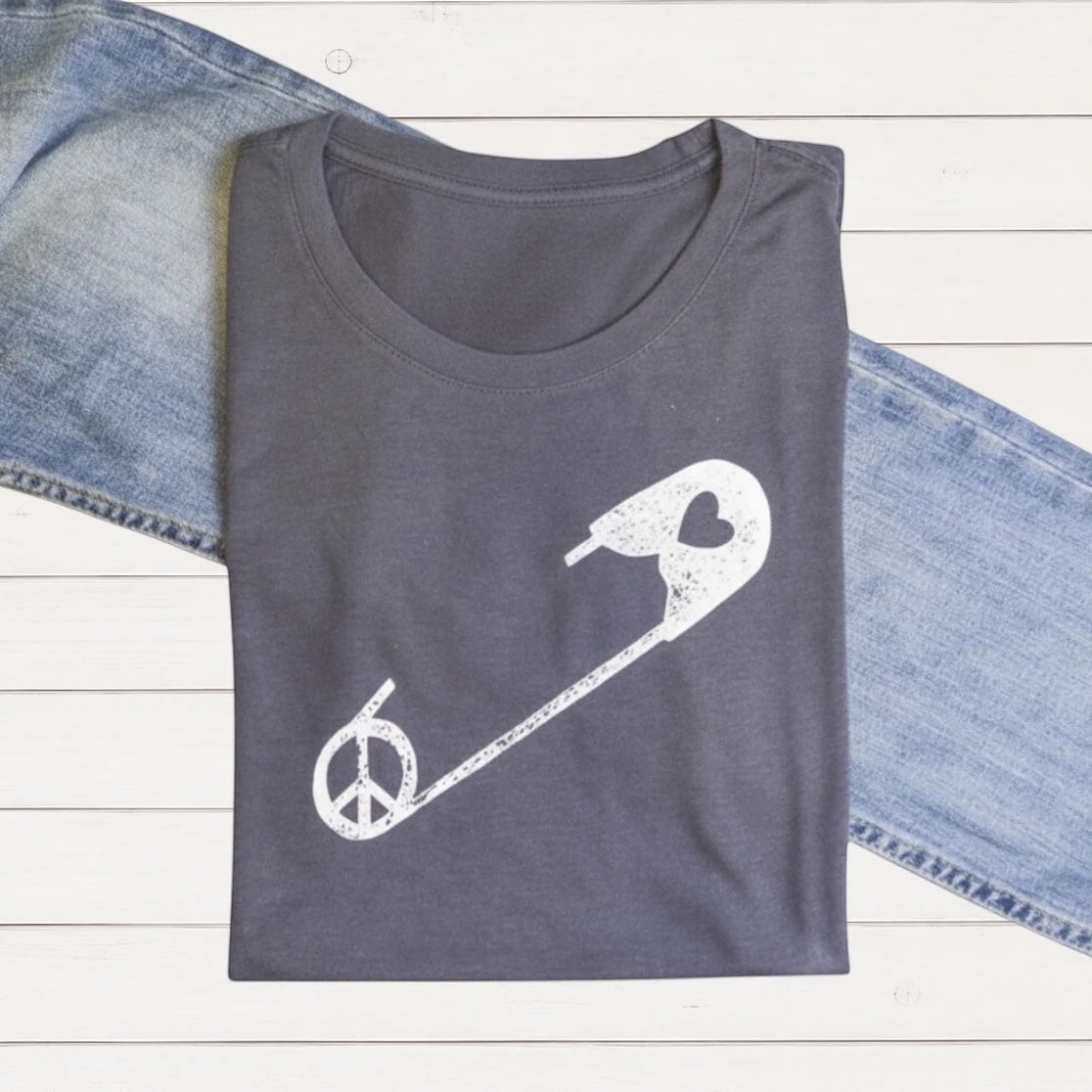 Gray women's graphic T-shirt made from bamboo and organic cotton featuring a white peace sign integrated with a safety pin and heart design, casual style