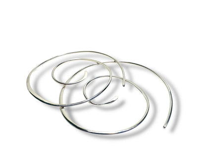 Silver Swirl Hoops - Set of sterling silver swirl earrings shown overlapping on a white background. Sleek, modern hoops for stylish accessorizing.