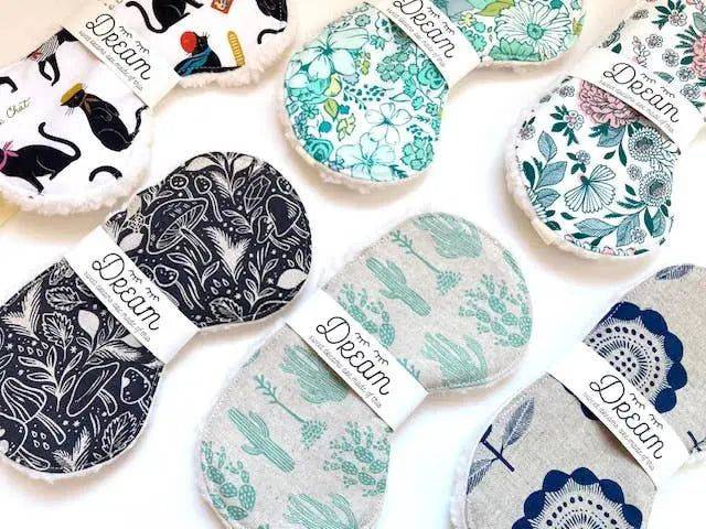Assorted cotton sleep masks for relaxation in various patterns including floral and botanical prints. Soft Sherpa lining and elastic bands for comfort.