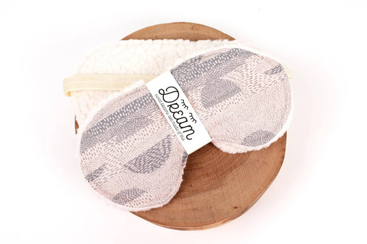 Sweet Dreams Sleep Mask with abstract cotton front and soft minky back, displayed on a wooden tray for home relaxation and comfort.