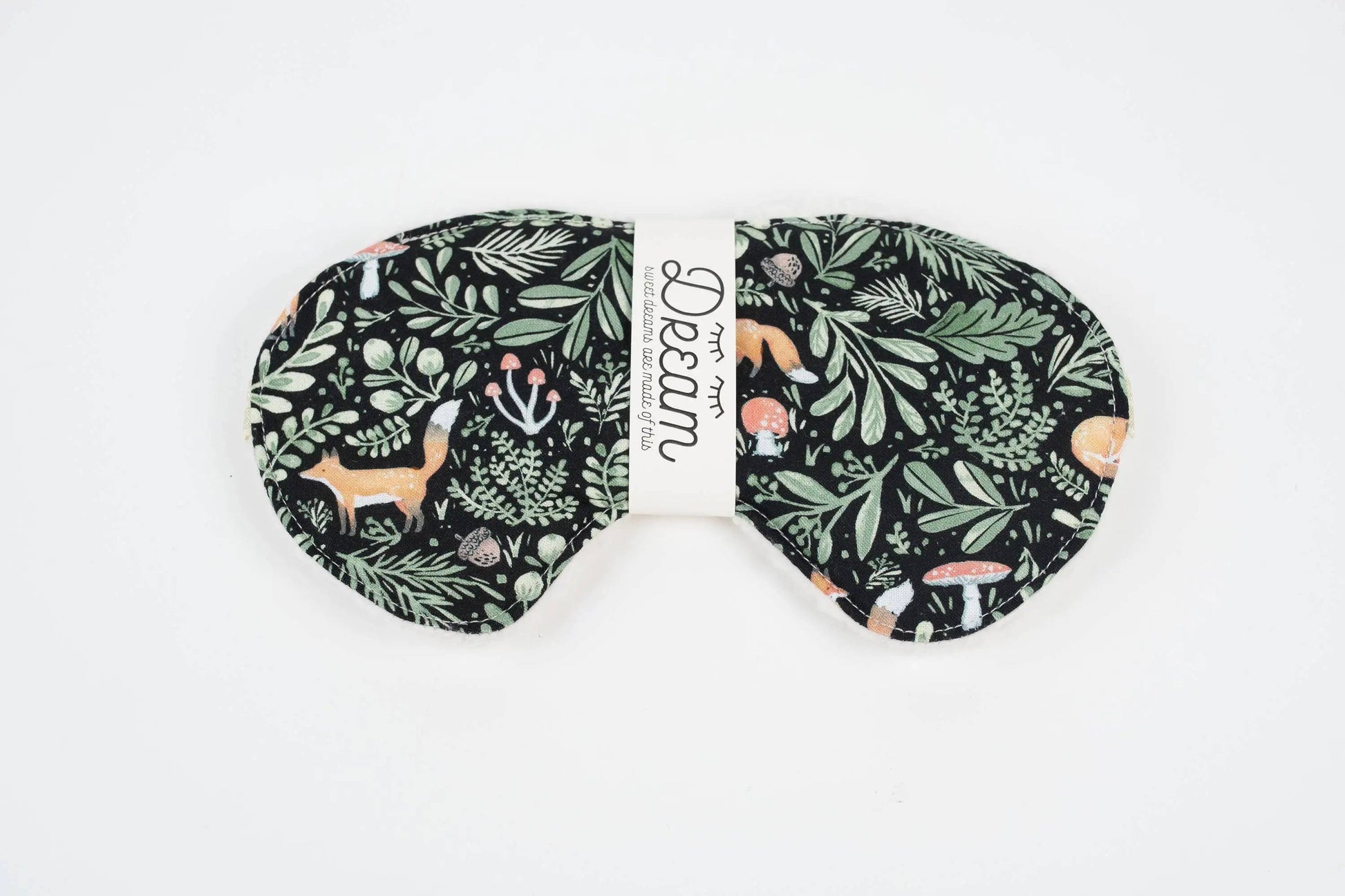 Front view of Sweet Dreams Sleep Mask featuring a whimsical forest animal and foliage design on soft black cotton. Perfect for blocking light during sleep.