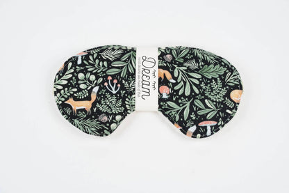 Front view of Sweet Dreams Sleep Mask featuring a whimsical forest animal and foliage design on soft black cotton. Perfect for blocking light during sleep.
