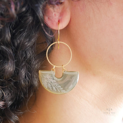 Emerald Earrings - Fern Moon Shadow worn on ear, featuring gold hoop and green resin with fern motif, perfect for holiday and seasonal wear.