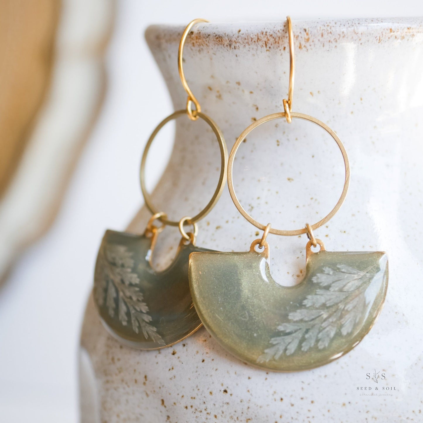 Close-up of Emerald Earrings - Fern Moon Shadow showing detailed fern leaf design in green resin with gold hoop, handcrafted holiday jewelry.