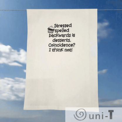 Stressed Desserts Towel - Embroidered | Absorbent & Fun shown outdoors on a clothesline, highlighting its playful design and quality fabric for kitchen use.