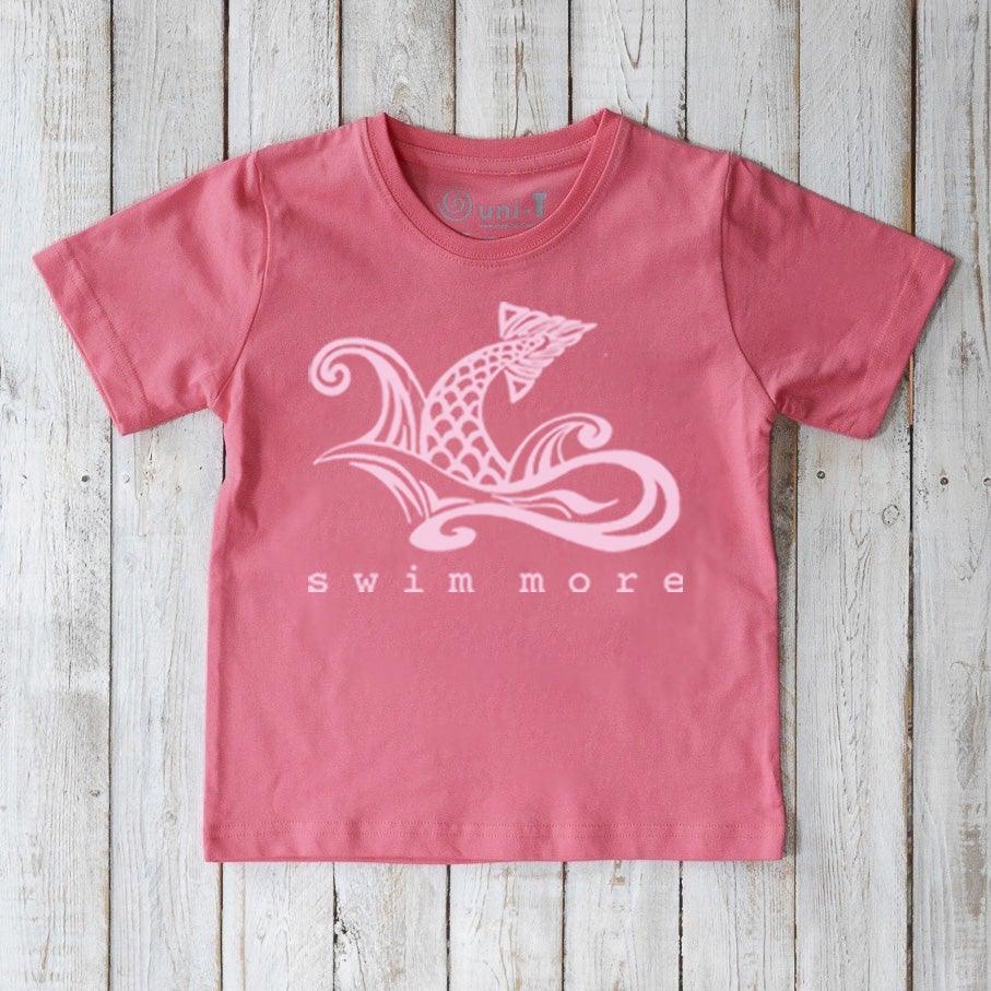 Eco-friendly Kids' Swim Organic Cotton T-Shirt in pink featuring white swimmer graphic and 'swim more' slogan, ideal for young swimmers.