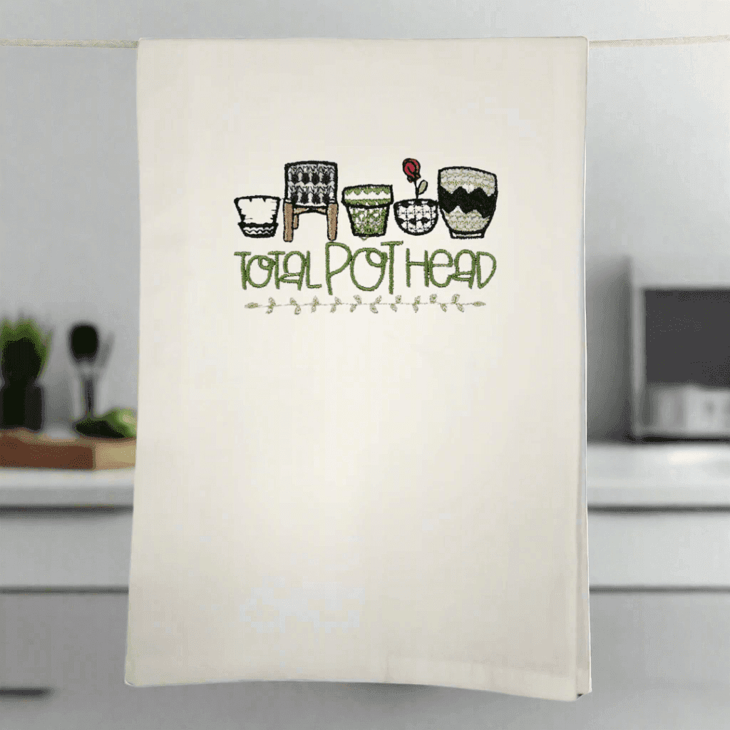 Total Pot Head Embroidered Towel - Plant-Themed Accessory hanging in a modern kitchen, showcasing quirky potted plant embroidery.