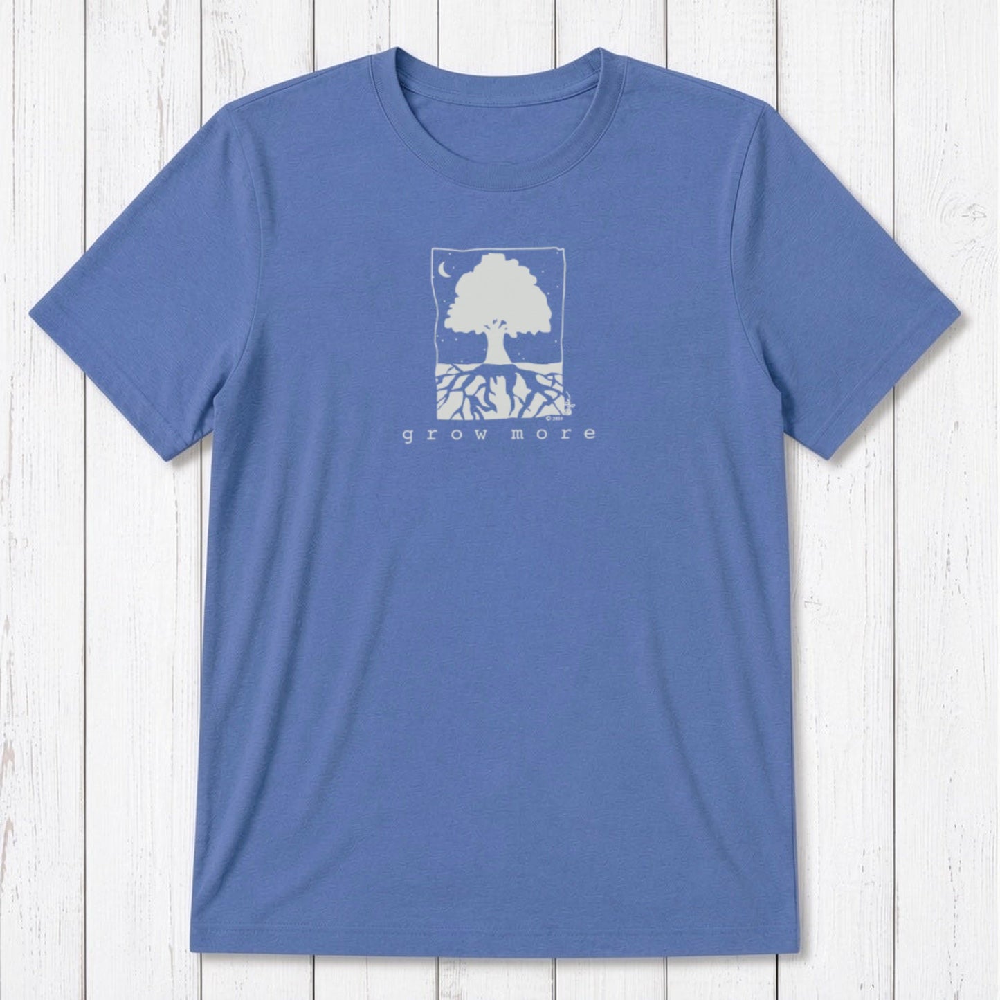 Sky blue men's 'Grow More' tree graphic t-shirt in bamboo and organic cotton, laid flat on rustic wood background.