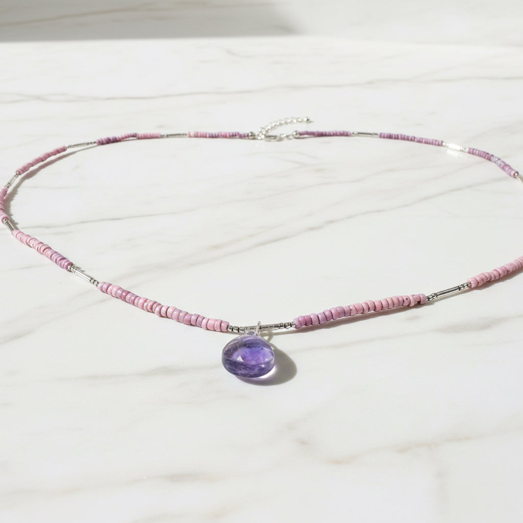 Pink beaded necklace with purple gemstone pendant and silver clasp