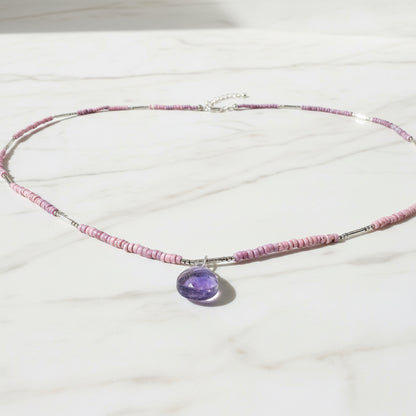Pink beaded necklace with purple gemstone pendant and silver clasp