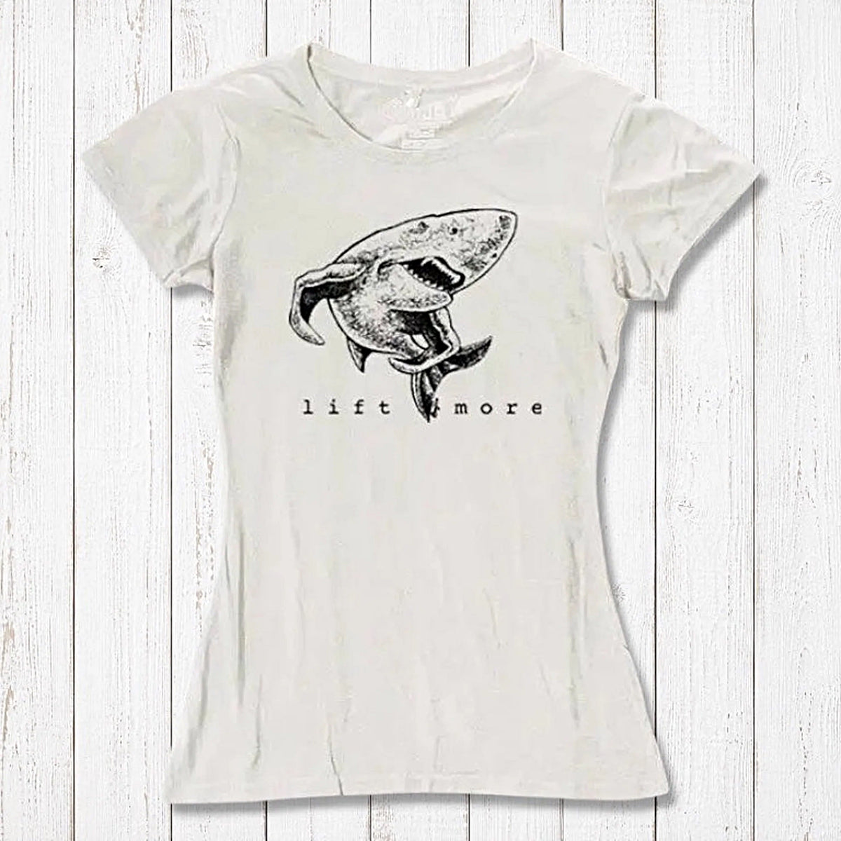 Natural white bamboo and organic cotton women's T-shirt featuring a shark and 'Lift More' text. Sustainable workout wear for lifters.