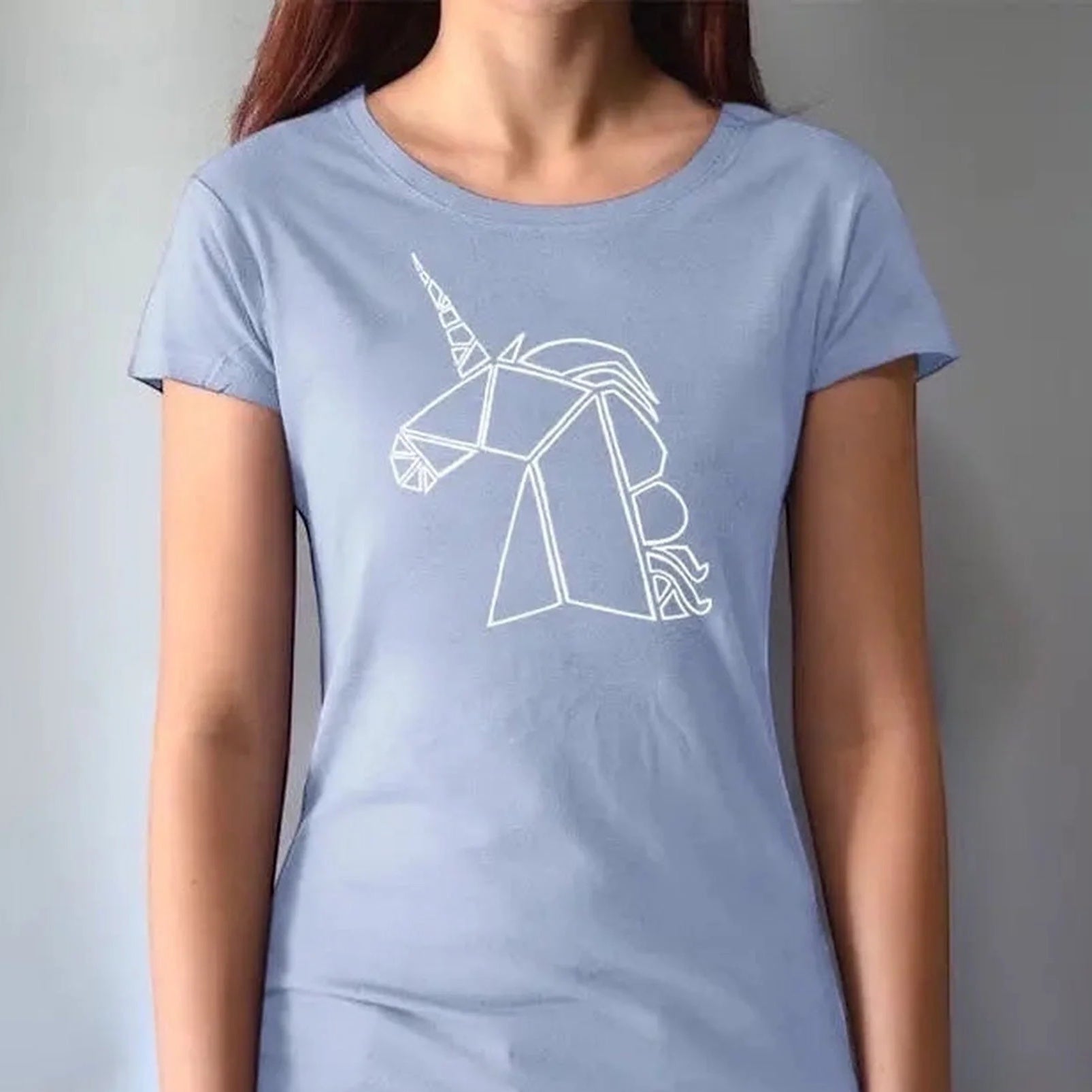 Model in light blue bamboo and organic cotton Women’s Unicorn T-Shirt with white geometric unicorn artwork. Sustainable and stylish fantasy-themed tee.