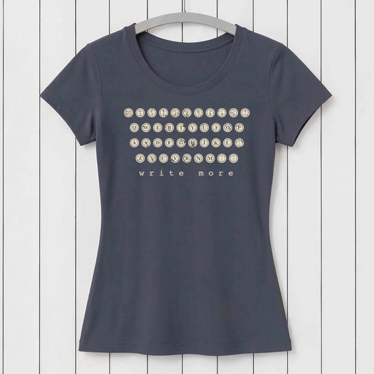 Dark gray women's T-shirt with vintage typewriter keyboard graphic and 'write more' text, made from soft organic cotton, hanging on a white wooden background
