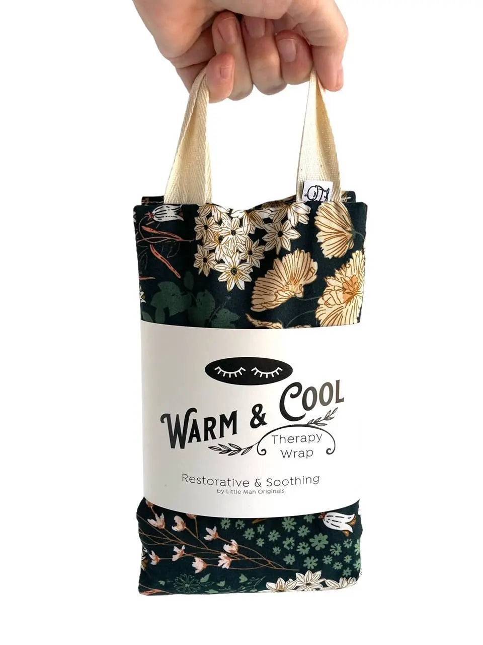 Hand holding floral cotton therapy wrap for neck pain, labeled for warm and cool natural pain relief with rice filling.