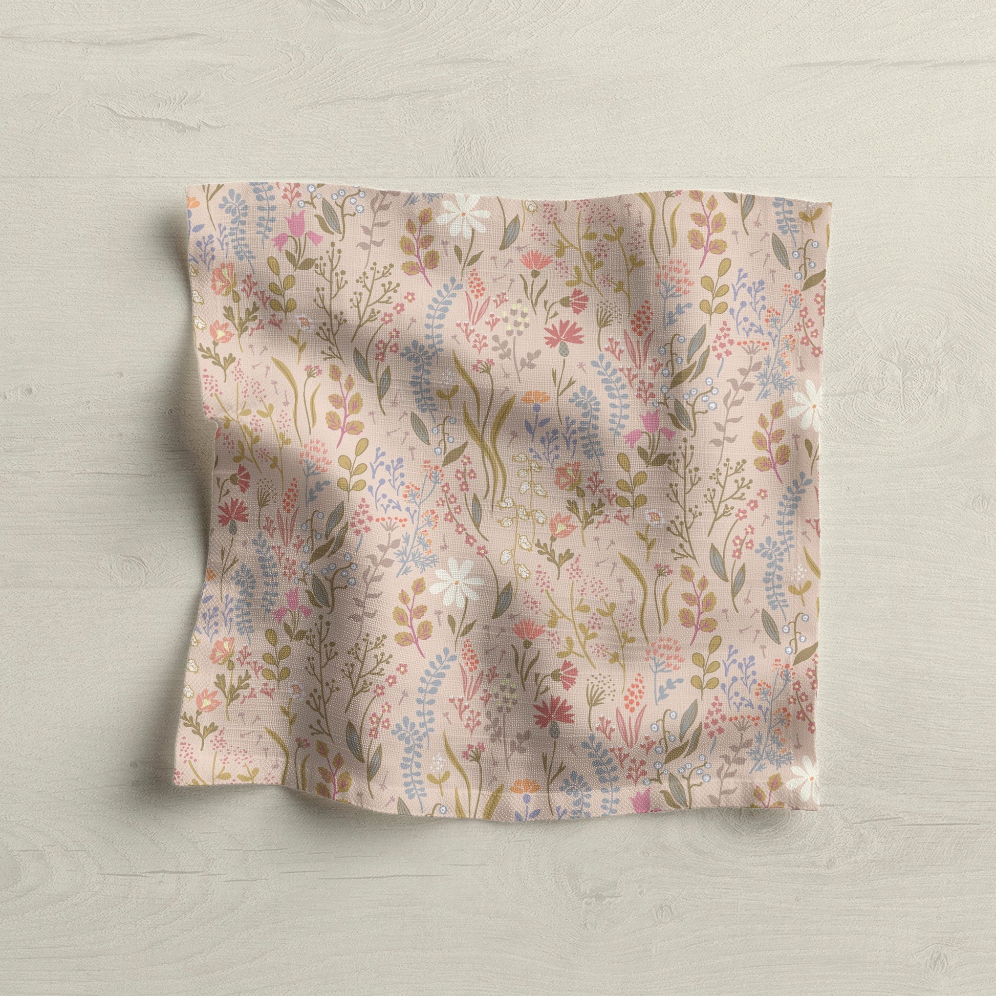 Floral linen napkin with pink, blue, and beige botanical print