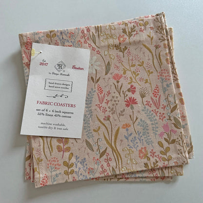 Set of fabric coasters with pink floral pattern and label