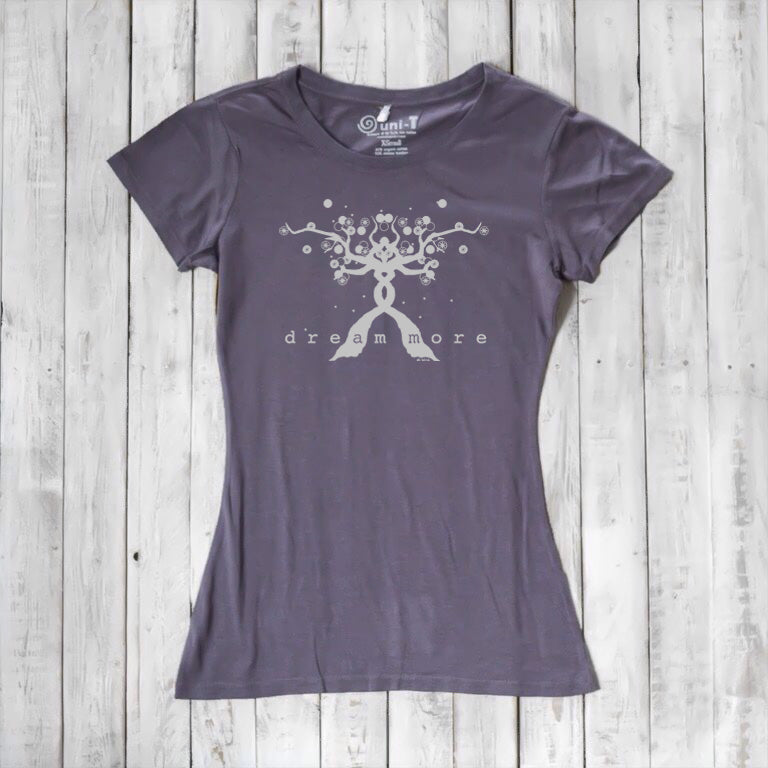 Charcoal gray Women's Motivational T-Shirt in Bamboo & Organic Cotton with light 'Dream More' tree graphic, flat lay on wood background.