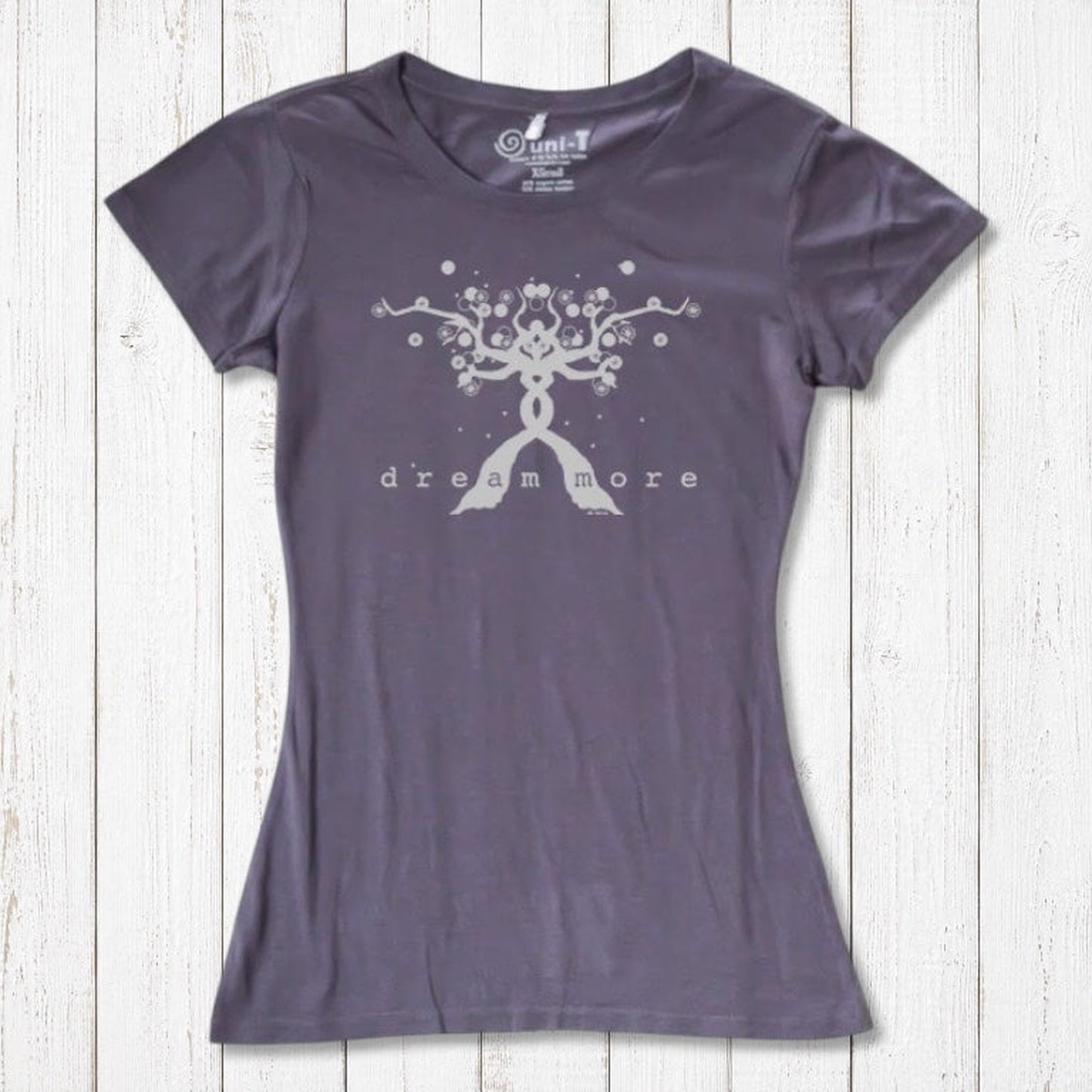 Charcoal gray Women's Motivational T-Shirt in Bamboo & Organic Cotton with light 'Dream More' tree graphic, flat lay on wood background.