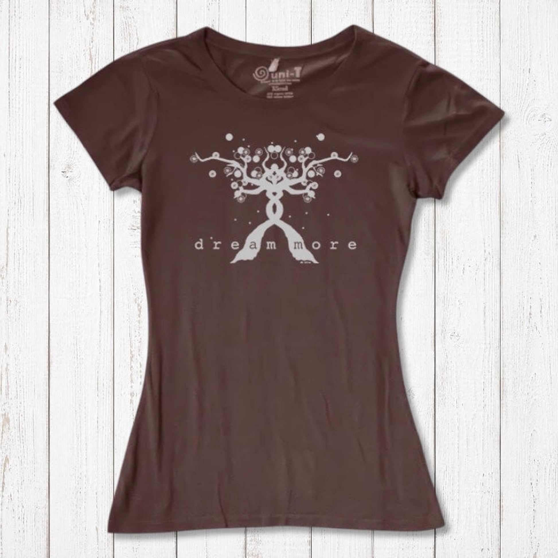 Brown Women's Motivational T-Shirt in Bamboo & Organic Cotton with subtle 'Dream More' tree graphic, displayed flat on wooden surface.