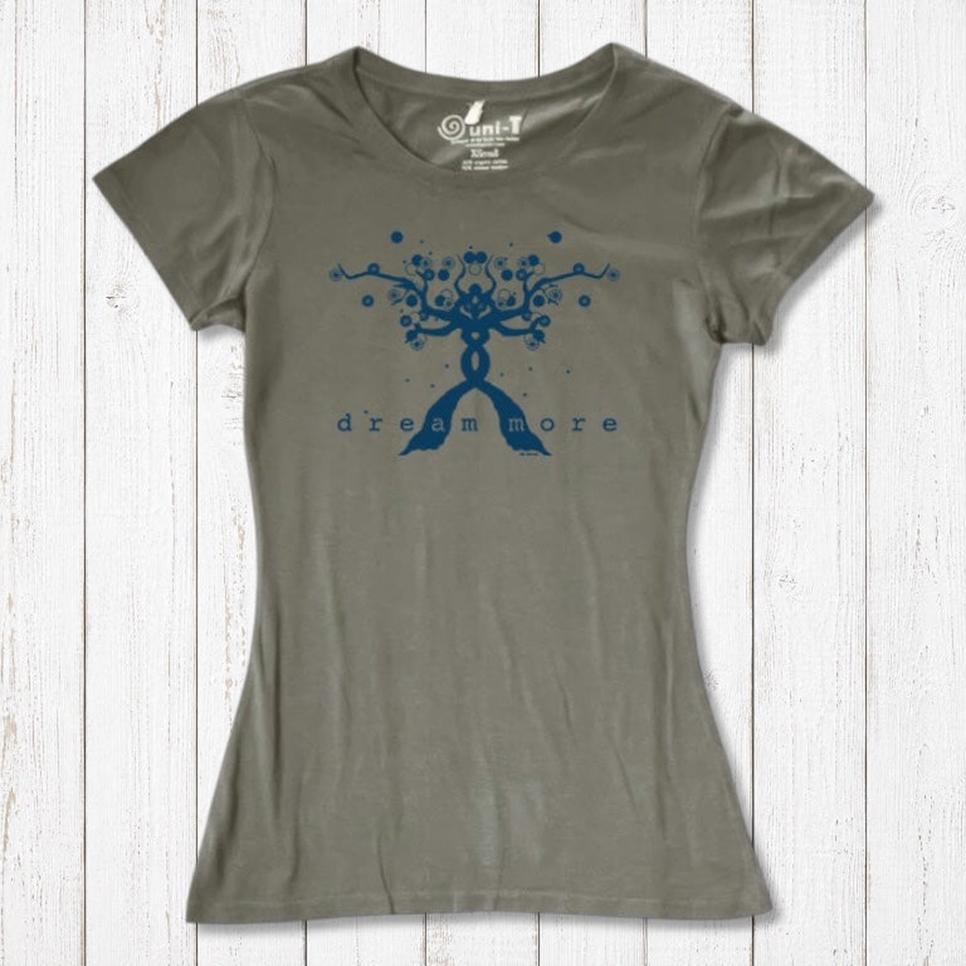 Olive green Women's Motivational T-Shirt in Bamboo & Organic Cotton with blue 'Dream More' tree graphic, flat lay on rustic wood.